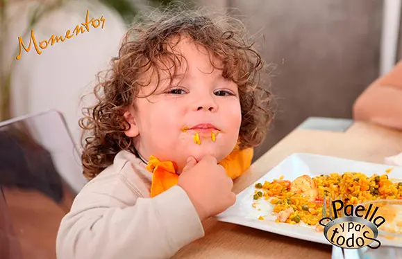 Niño comiendo una deliciosa paella en Bogotá